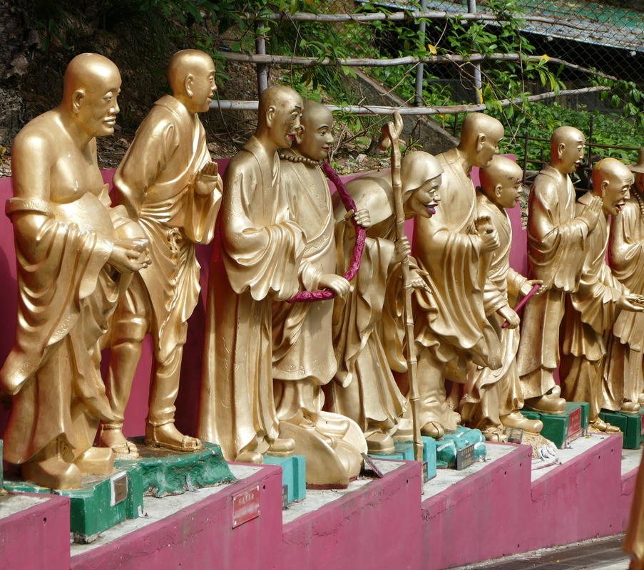 life-size, gold-plated monks lining the path to the temple