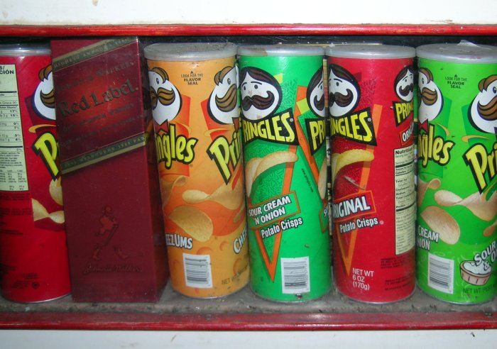 Several kinds of Pringles chips and a box of Johnnie Walker Red.