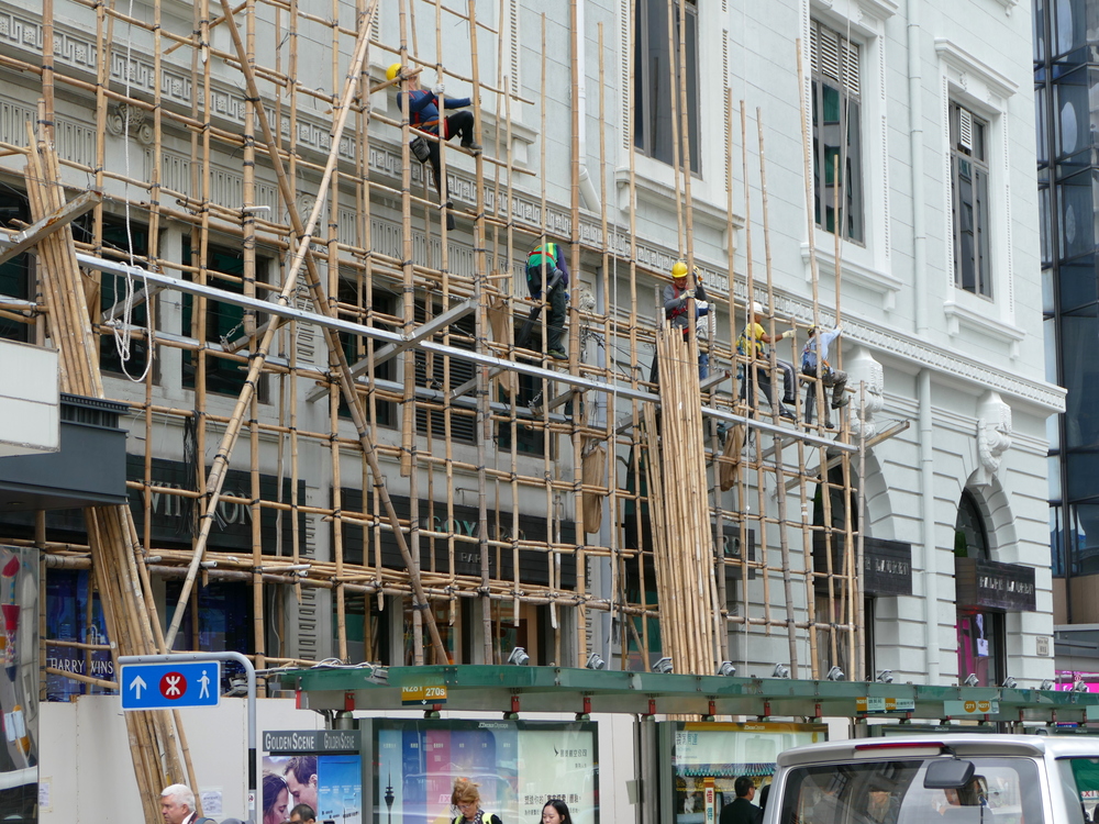 Men crawling up the second and third storey of bamboo scaffolding