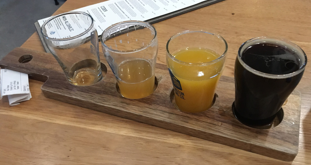 four small beers, one empty, the double IPA nearly empty, one bright orange, and one very dark
