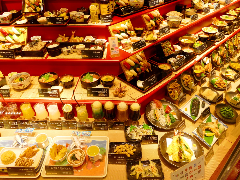 Multiple Japanese meals displayed incredibly convincingly in plastic, advertising a restaurant