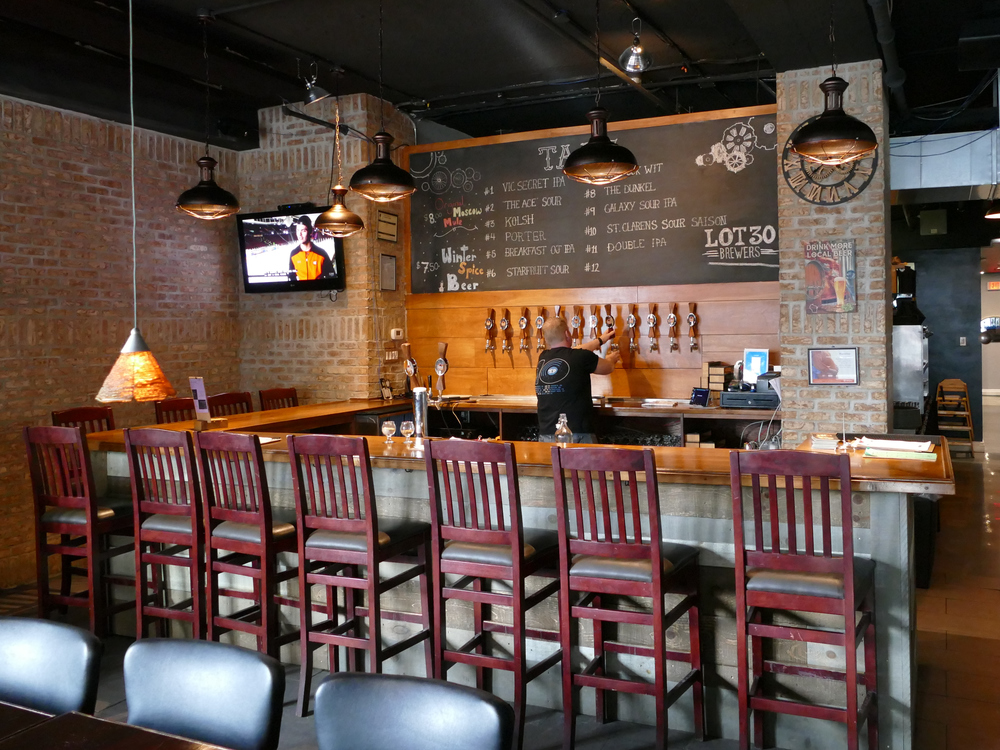 wood bar and stools, chalk board menu behind multiple taps.