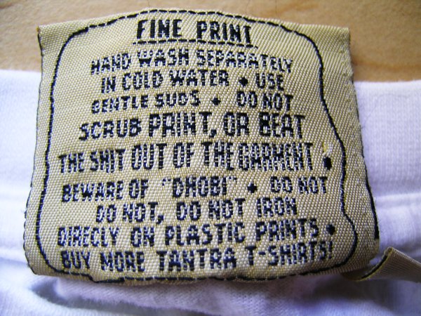 t-shirt tag that says "Do not scrub print, or beat the shit out of the garment"