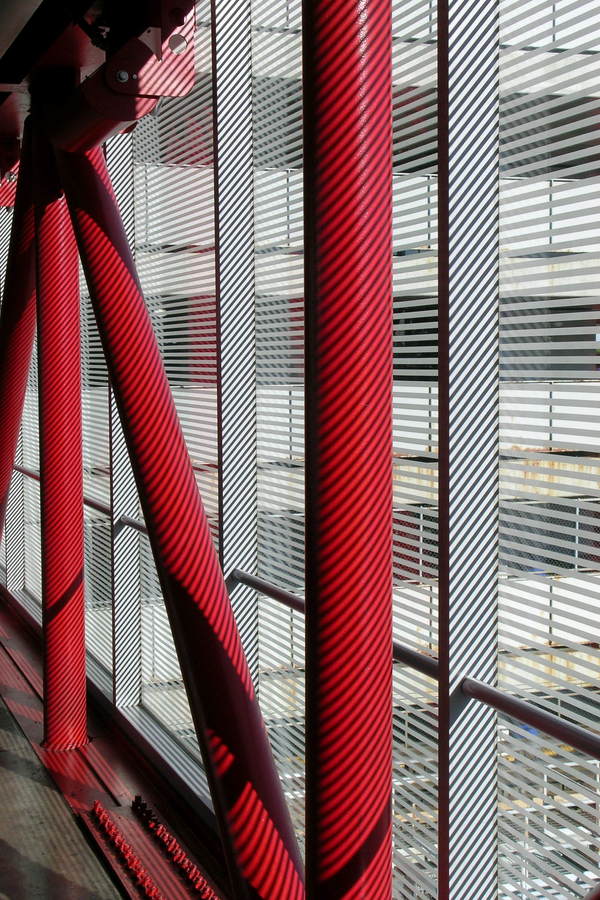red pillars in a Chicago O'Hare corridor striped by shadows.