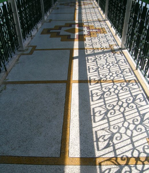 a tiled walkway with patterned shadows
