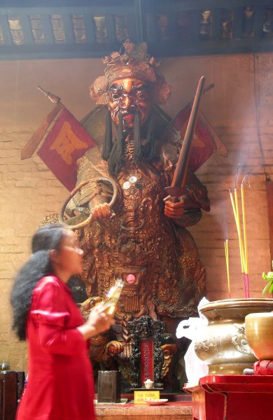 Woman praying beside a menacing warrior