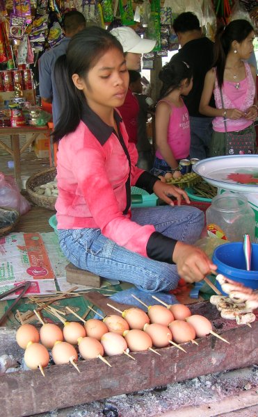 Vendor preparing eggs on a stick
