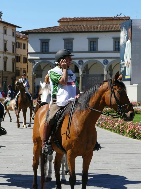 Man in Santa Maria Novella Piazza on a horse ... on a cellphone.